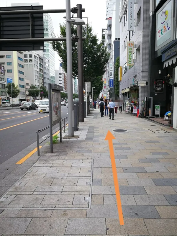 青山通りをまっすぐ進む方向を示した写真（オレンジ矢印付き）