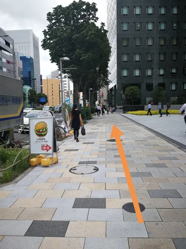 青山通り沿いのエイベックスビル前を通る様子（オレンジ矢印付き）