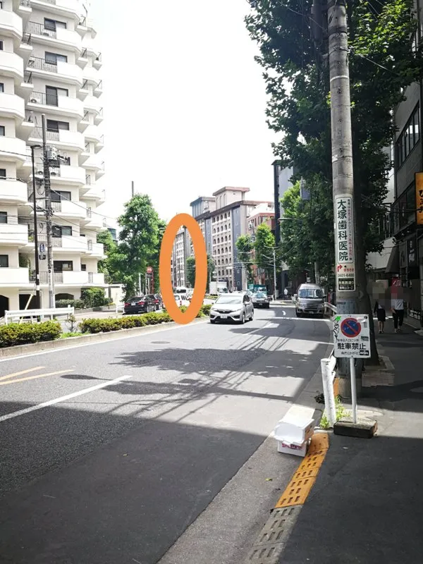 坂を下る途中で見える李哲鍼灸院が入るビルをオレンジ楕円で囲んだ写真