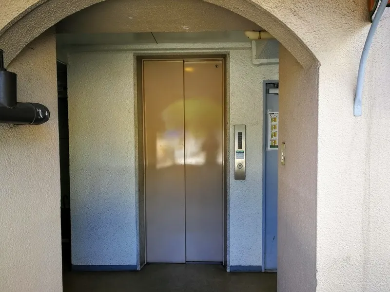 階段を上がった場所にあるエレベーターの写真