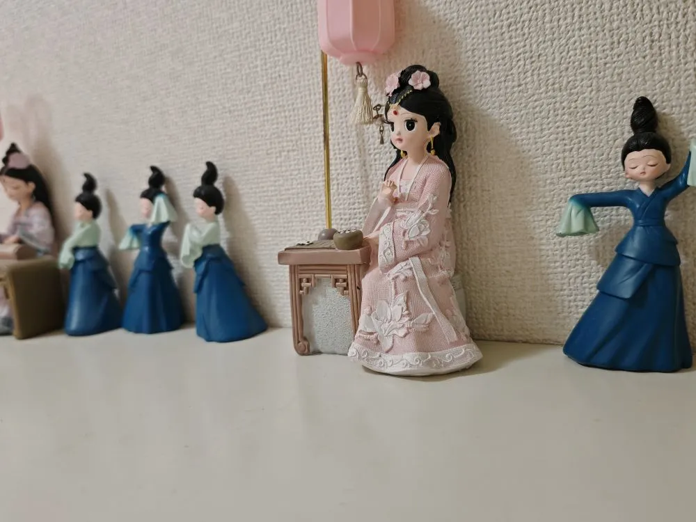 中国宮廷風の古琴を弾く女性と踊る女性の小さな模型が靴棚に飾られている。